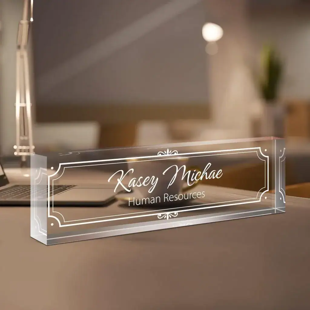 A clear acrylic desk name plate with 'Kasey Michae' and 'Human Resources'.
