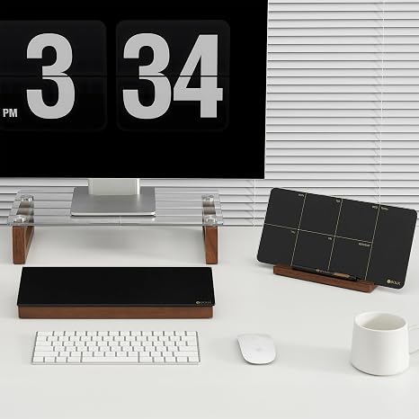 White desk with digital clock, keyboard, mouse, and black organizer blocks.