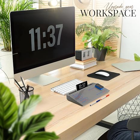 Workstation with large digital clock on monitor and organized accessories.