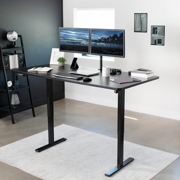 Adjustable standing desk with dual monitors, black tabletop, and ergonomic design for healthy worksp.