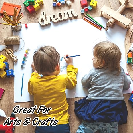Bright children creating art on large white poster paper with craft supplies and wooden toys.