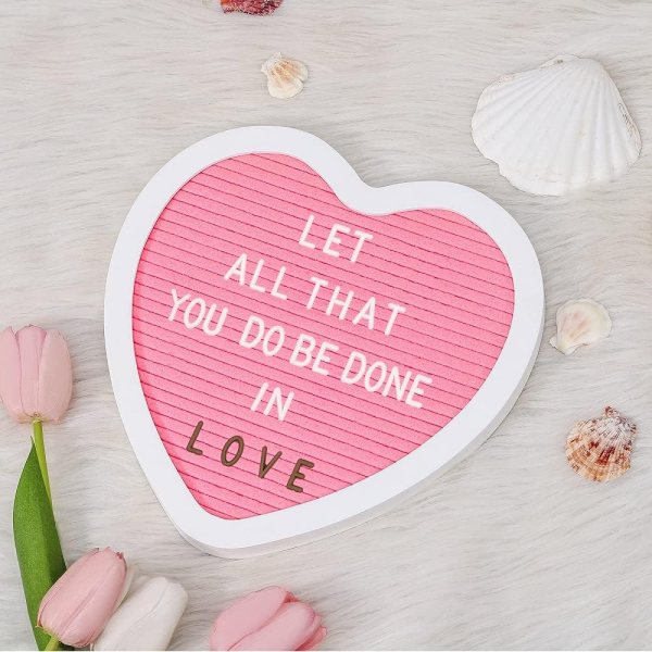 Heart-shaped letter board with inspirational message and decorative seashells.